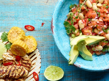 Poulet avec une salade épicée de tomates et haricots blancs