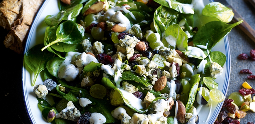 Salade de jeunes feuilles d'épinards aux raisins, au fromage bleu et au mélange de noix grillées