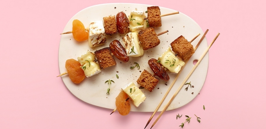 Brochette de brie fondu, pain d’épices, dattes et abricots secs