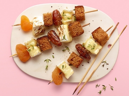 Brochette de brie fondu, pain d’épices, dattes et abricots secs