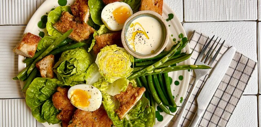 Salade César au veau pané, croûtons, œufs mollets et légumes verts